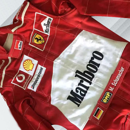 2004 Michael Schumacher Ferrari F1 embroidered racing suit in Ferrari red. Sponsor logos feature on the chest and sleeves of the suit, which also bears Schumacher's name and includes very detailed embroidery for his record-breaking seventh championship season.