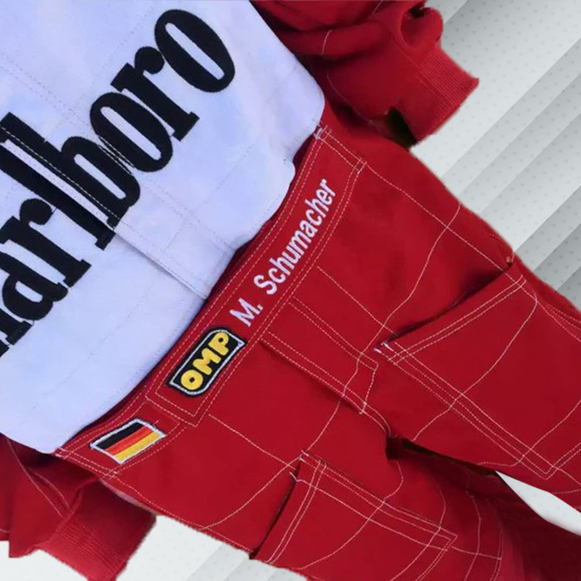 2004 Michael Schumacher Ferrari F1 embroidered racing suit in Ferrari red. Sponsor logos feature on the chest and sleeves of the suit, which also bears Schumacher's name and includes very detailed embroidery for his record-breaking seventh championship season.